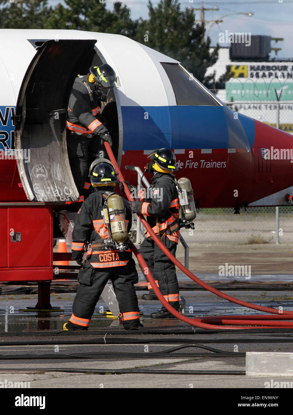 (150430) -- VANCOUVER, Aprile 30, 2015 (Xinhua)--Vigili del Fuoco portano il tubo flessibile in un aeromobile durante una situazione di emergenza esercitazione all'Aeroporto Internazionale di Vancouver a Vancouver, Canada, 29 aprile 2015. Aeroporto Internazionale di Vancouver ha ospitato un'emergenza esercitazione, la simulazione di un incidente aereo avvenuto in aeroporto per la pratica dei piani di risposta alle emergenze con le diverse parti. Più di 600 partecipanti di 30 agenzie sono stati coinvolti nell'esercizio. (Xinhua Liang/sen)(azp) Foto Stock