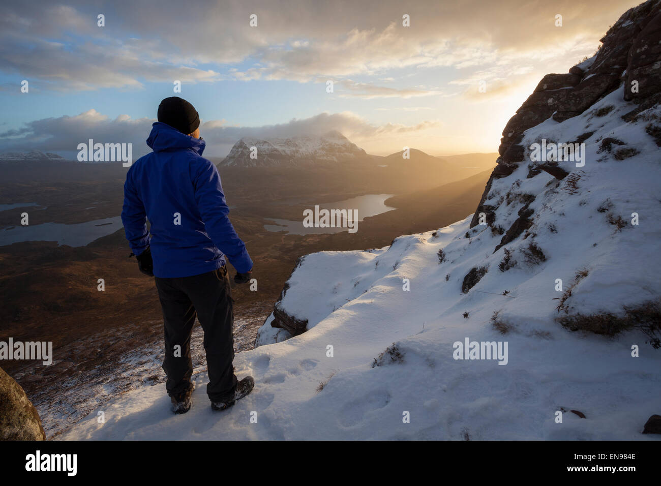 Un viandante guarda il sorgere del sole sulla cima di Stac Pollaidh. Foto Stock