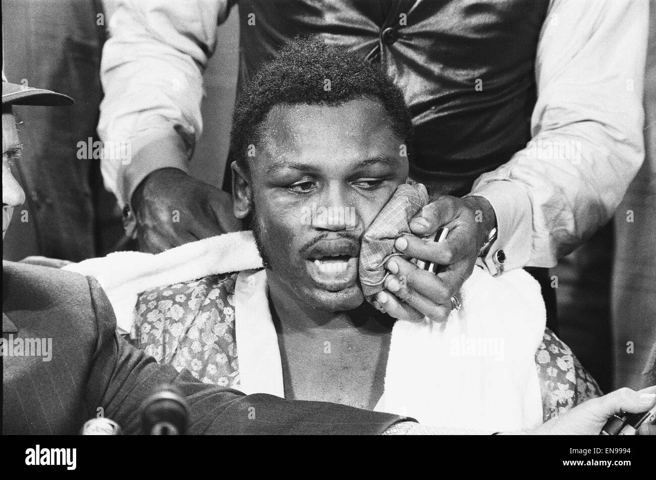 Joe Frazier visto qui dando una conferenza stampa mentre un assistente applica una borsa di ghiaccio per il suo volto a ridurre il rigonfiamento in seguito alla lotta contro Muhammad Ali. Frazier ha vinto la battaglia che era stata tenuta al Madison Square Garden di New York. 9 Marzo 1971 Foto Stock