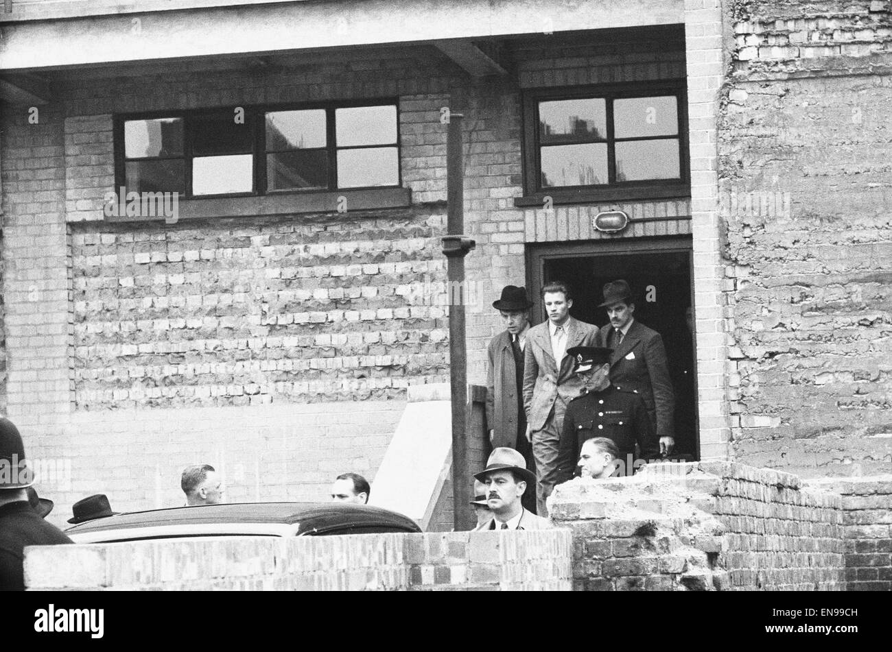 Charles James Geraghty essendo portato da Tottenham Court Road stazione di polizia dopo essere stato caricato con l'assassinio di Alec d'Antiquis. 21 Maggio 1947 a 2pm lunedì 28 aprile 1947 tre banditi mascherati scoppiò in Jay gioiellerie in Charlotte Street, London W1. Foto Stock