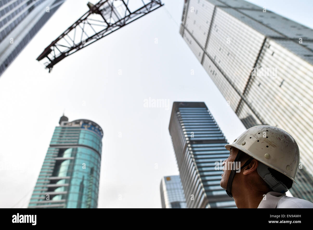 (150430) -- SHENZHEN, Aprile 30, 2015 (Xinhua) -- Foto scattata il 20 aprile 2015 mostra Wang Hua, una gru a torre operatore, guarda lo smantellamento di una gru a torre a Shenzhen, Cina del sud della provincia di Guangdong. Wang Hua, un 50-anno-vecchio dalla Cina centrale della Provincia di Henan, è una buona mano nel funzionamento della gru a torre. Se ha usato per essere una guardia di sicurezza quando era giovane, egli è cresciuta rapidamente in un eccellente gru a torre operatore a causa la sua diligenza e amore per l'apprendimento. Egli è stato impegnato in molte grandi progetti di costruzione come il nuovo sito di sistemi TVCC e il Water Cube e il progetto corrente è worki Foto Stock