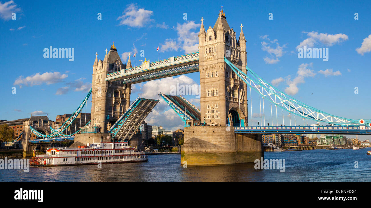 Una vista panoramica di Tower Bridge apertura fino oltre il Tamigi per lasciare una nave passa al di sotto. Foto Stock