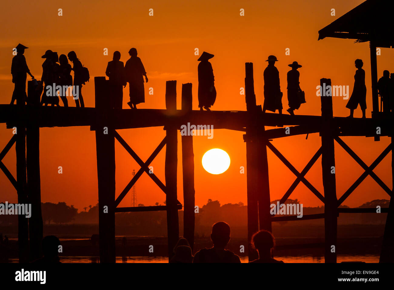 Le persone che attraversano il ponte di legno al tramonto, U- bein bridge, Mandalay Myanmar. Foto Stock