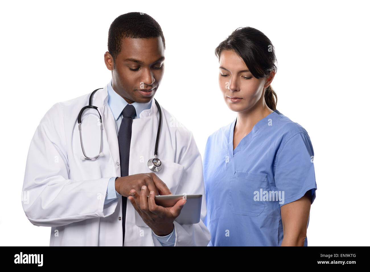 Due colleghi medici di avvalersi della consulenza di un tablet pc per la ricerca di record di paziente e grafici con un bel giovane medico africana in un wh Foto Stock