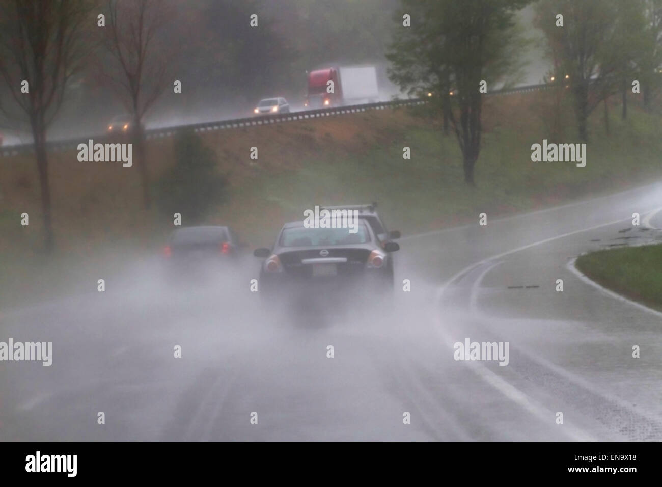 Vista di veicoli sulla superstrada attraverso la guida pericolosa, bagnato e bassa vvisibility condizioni atmosferiche Foto Stock