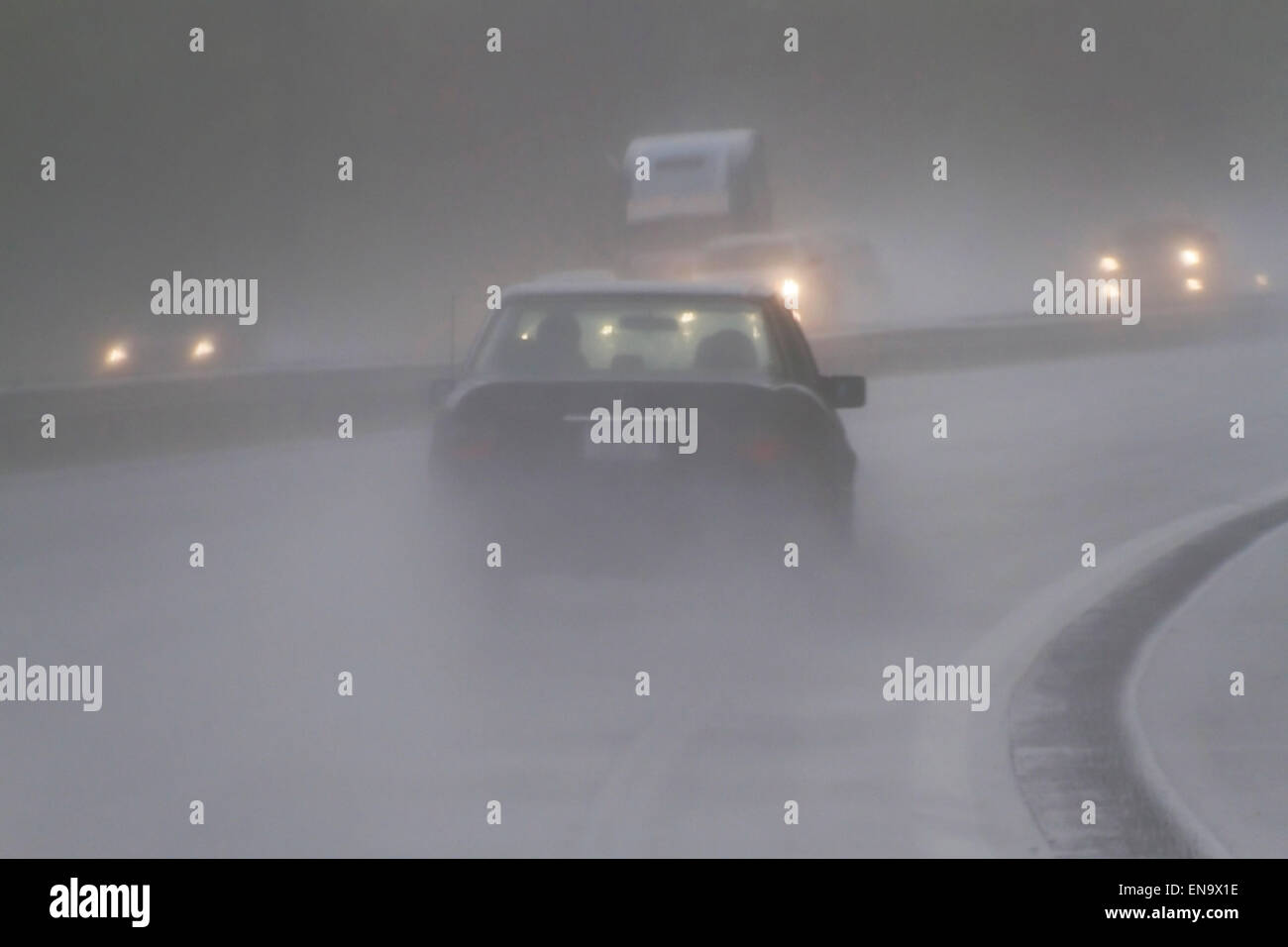 Vista di veicoli sulla superstrada attraverso la guida pericolosa, bagnato e bassa vvisibility condizioni atmosferiche Foto Stock