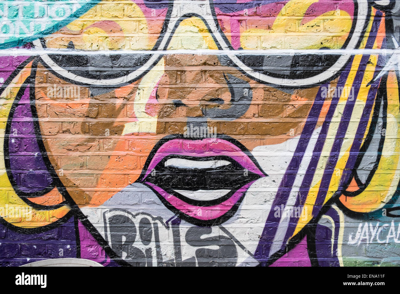 Street Art graffiti faccia colorati sulla parete Foto Stock