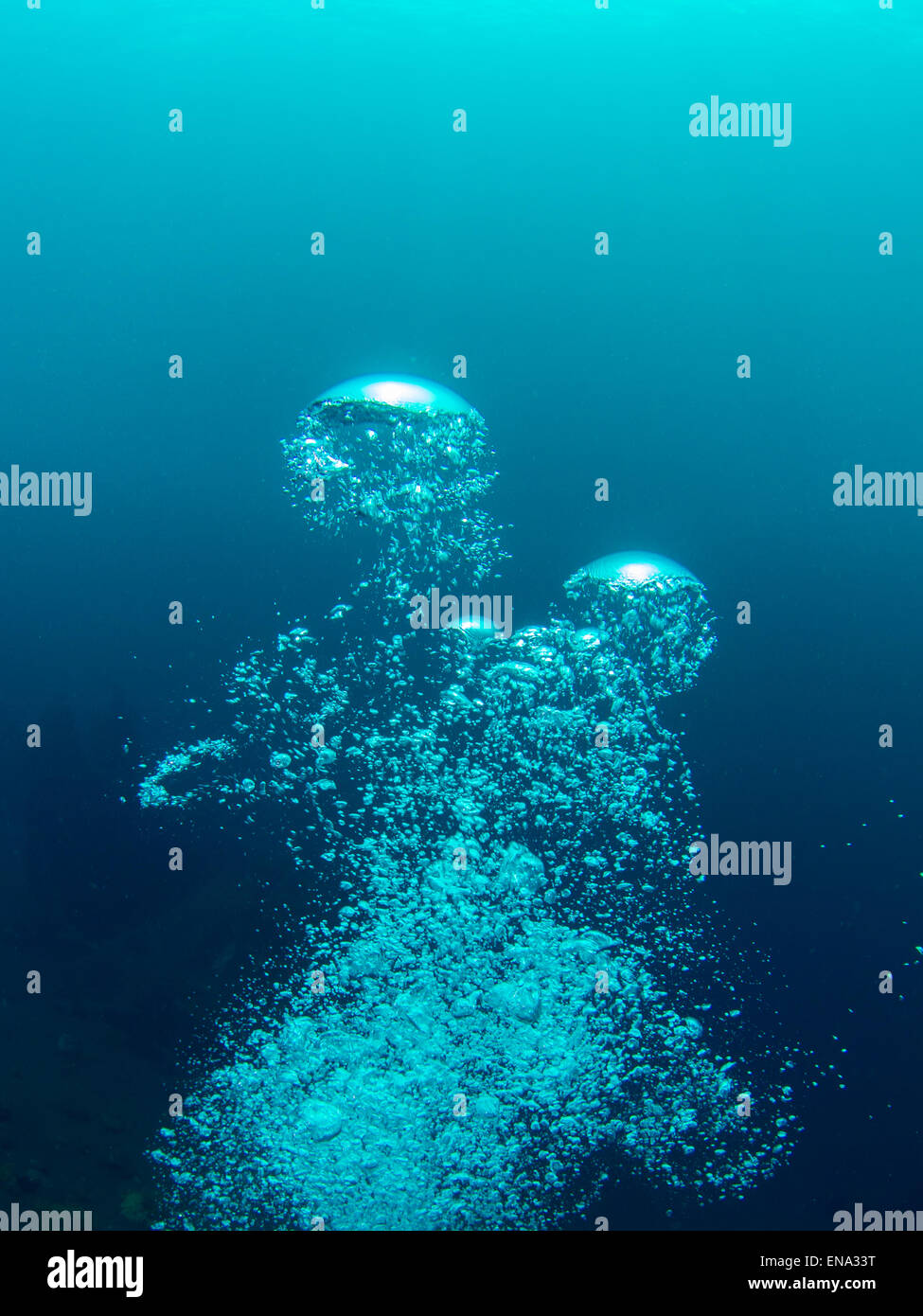 Bolle di un subacqueo lentamente risalire in superficie di espansione e di rompere di nuovo. Foto scattata durante una immersione in Bali Foto Stock
