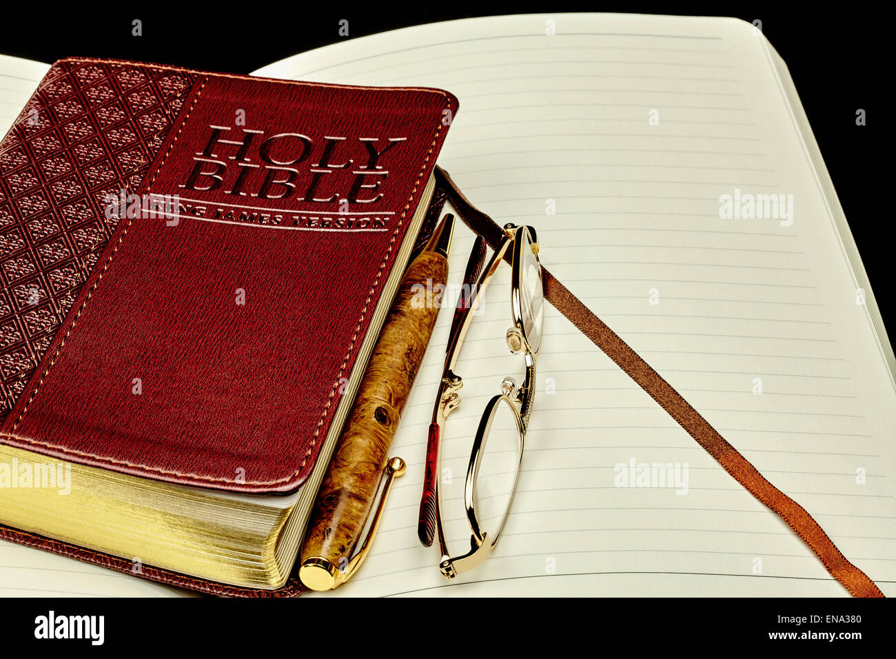 Generico chiuso Prop libro della Bibbia con un diario personale diario e penna di business e gli occhiali da lettura Foto Stock