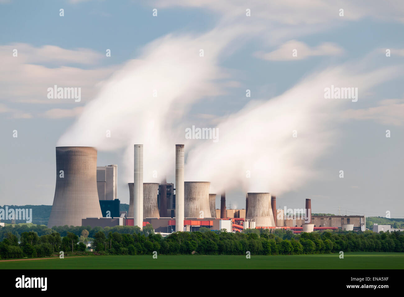 Una lunga esposizione colpo di una centrale elettrica a carbone nella distanza nel paesaggio agricolo. La stazione di potenza Niederaussem ha t Foto Stock