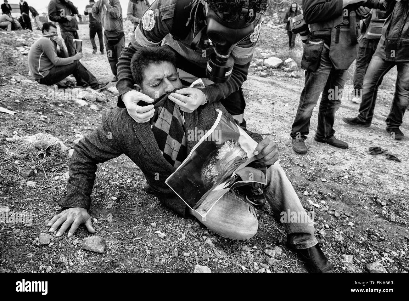 La Palestina. Il 7 dicembre, 2013. Un uomo con un poster di Nelson Mandela è assistito da personale medico dopo un israeliano di gas lacrimogeni in attacco Nabi Saleh. 7 dicembre, 2013. In Cisgiordania, la Palestina. © Gabriel Romero/ZUMA filo/Alamy Live News Foto Stock