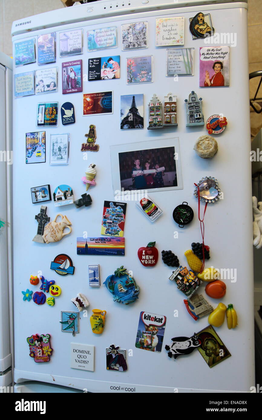 Un frigorifero domestico (refirgerator) coperto di magneti per il frigo Foto Stock