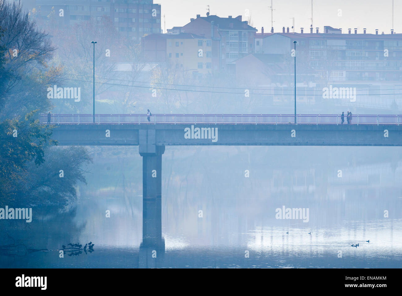 I pedoni che attraversano il ponte su un tetro inverno mattina Foto Stock