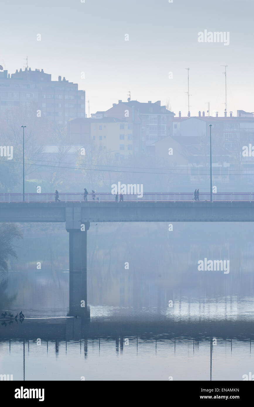 I pedoni che attraversano il ponte su un tetro inverno mattina Foto Stock