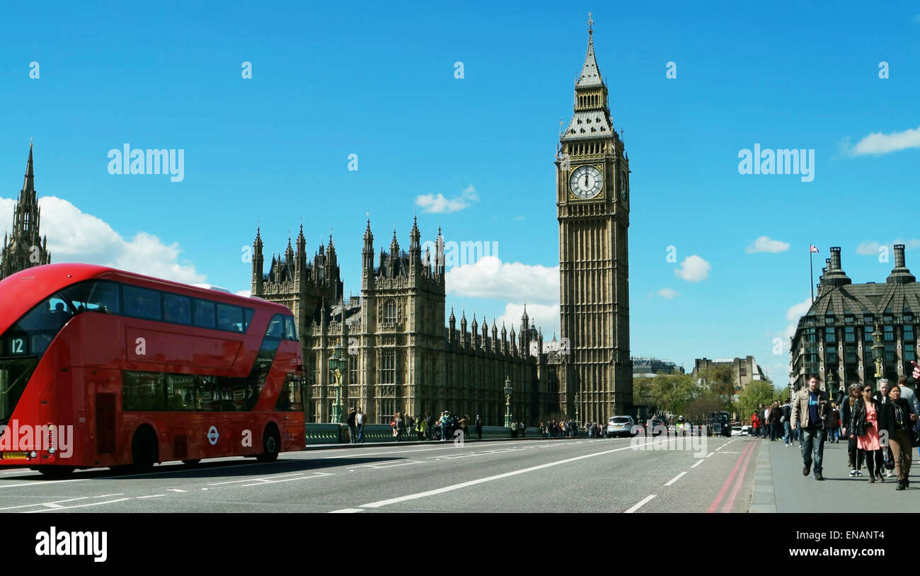 Il Big Ben e il Parlamento come un rosso autobus Routemaster passa da. Blu cielo con soffici nuvole. Foto Stock