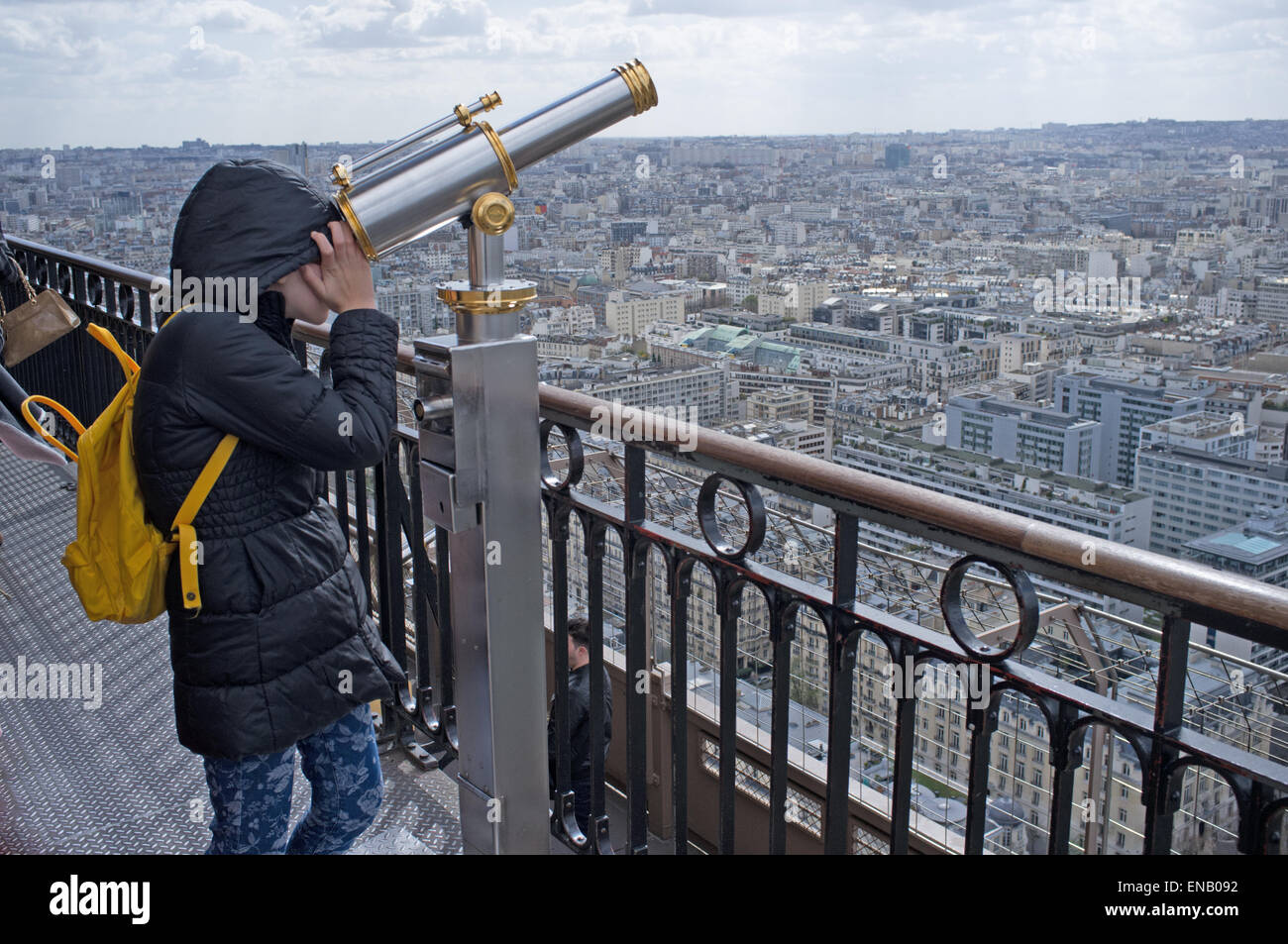 Un bambino guardando attraverso un telescopio sulla Torre Eiffel Foto Stock