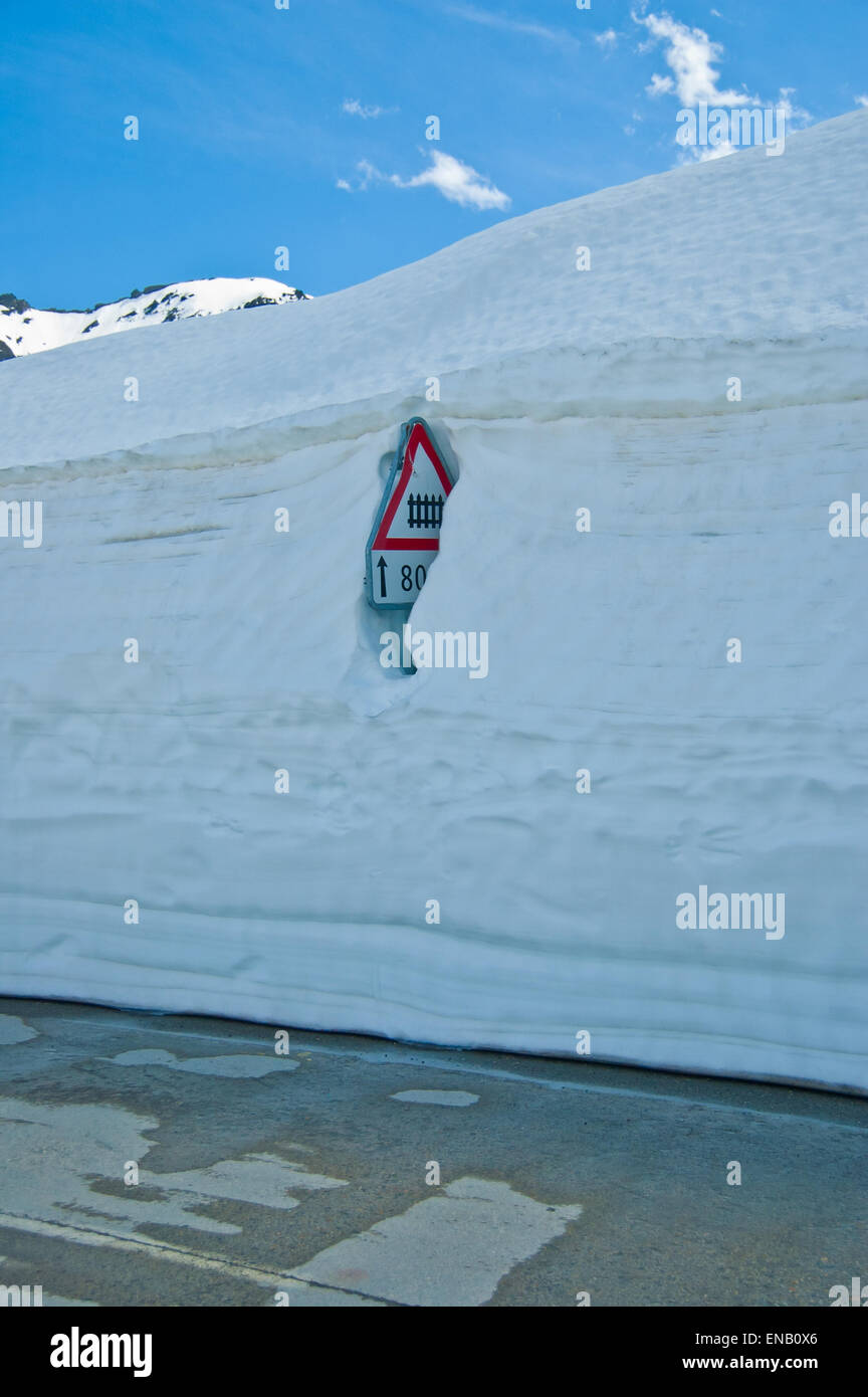 Cartello stradale sommersa dal muro della neve, Nufenen pass Foto Stock