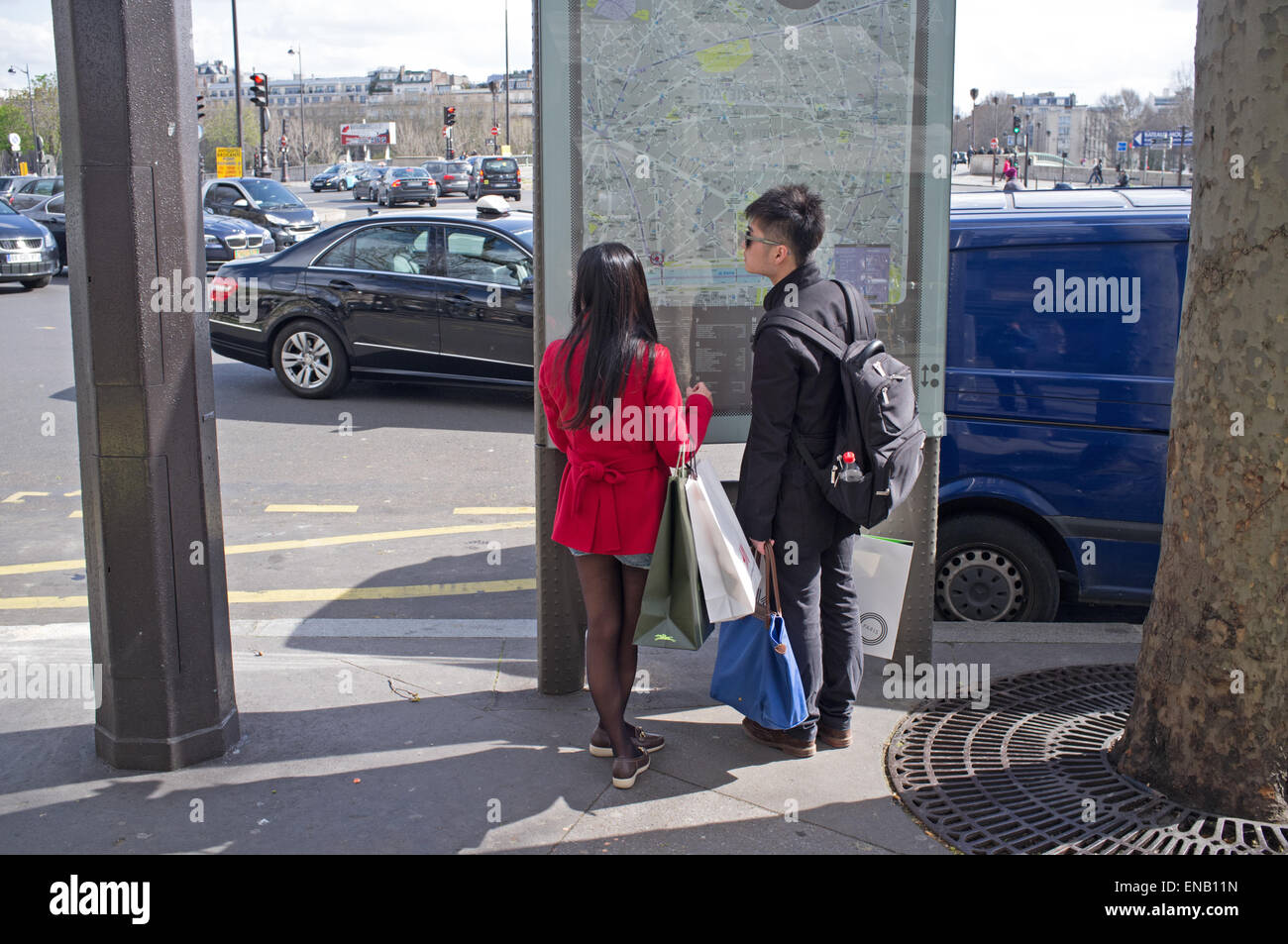 Due turisti giapponesi guardando una mappa a Parigi, Francia Foto Stock