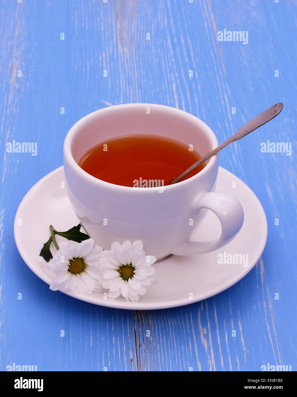 White tazza da tè e fiori blu su sfondo di legno, verticale Foto Stock