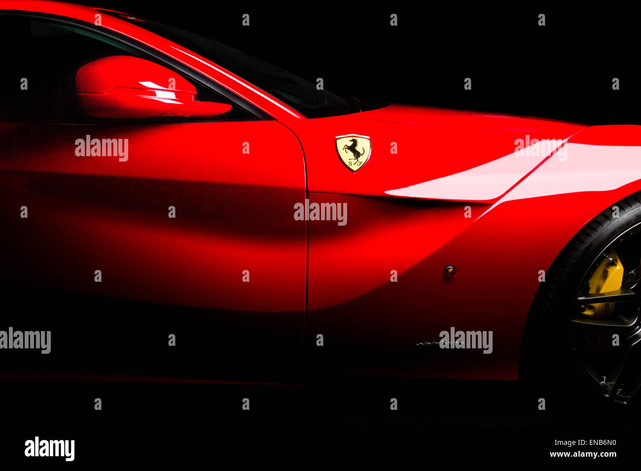 Ferrari F12 in rosso side shot di sfiato, specchi e logo su sfondo nero. Foto Stock