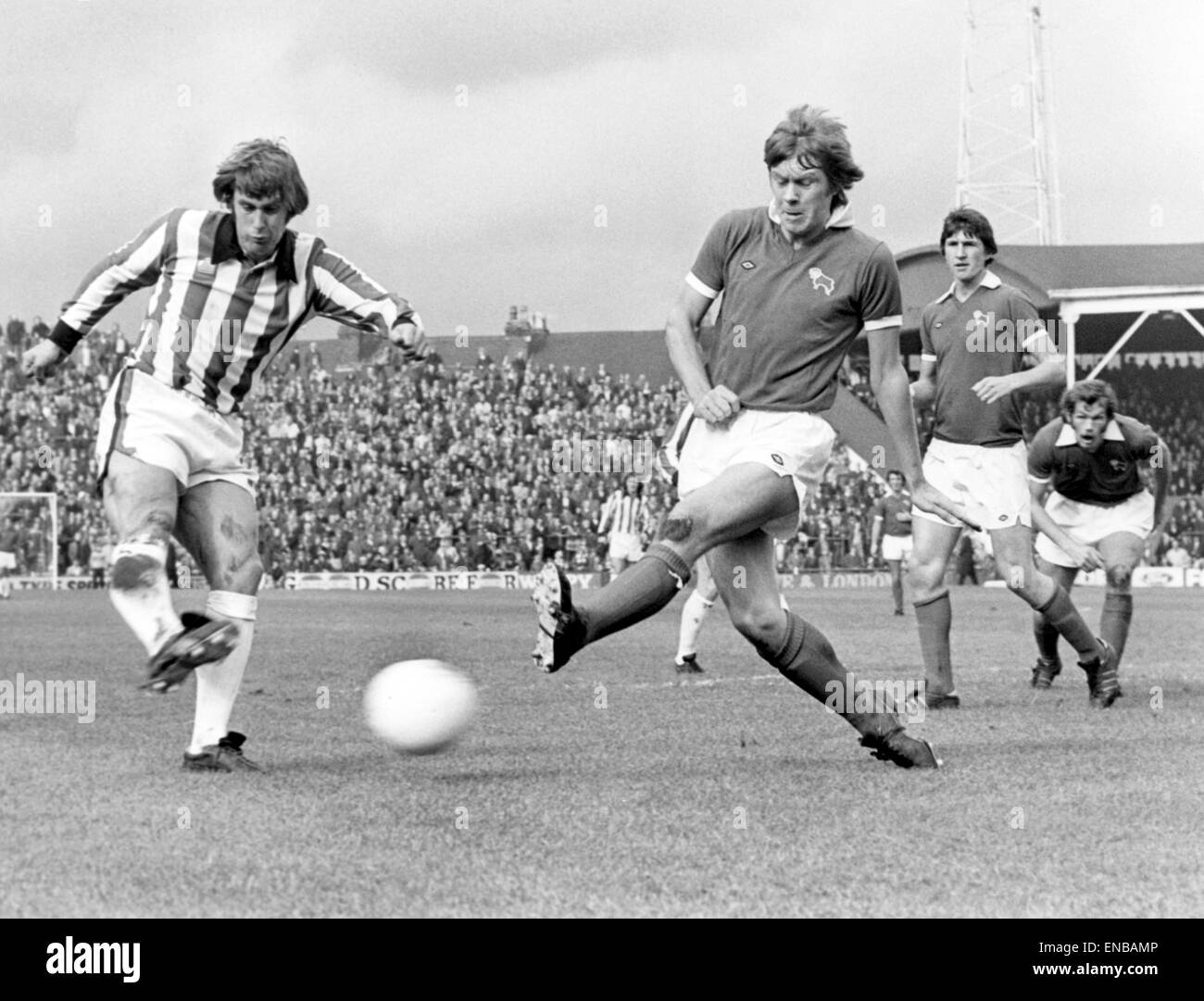 Stoke v Derby league match presso il Victoria terra, sabato 28 settembre 1974. Geoff Hurst di Stoke poteri un full blooded drive al Derby obiettivo che è andato largo, battendo fuori da un affrontato da David Nish. Punteggio finale: Stoke 1-1 Derby. Foto Stock