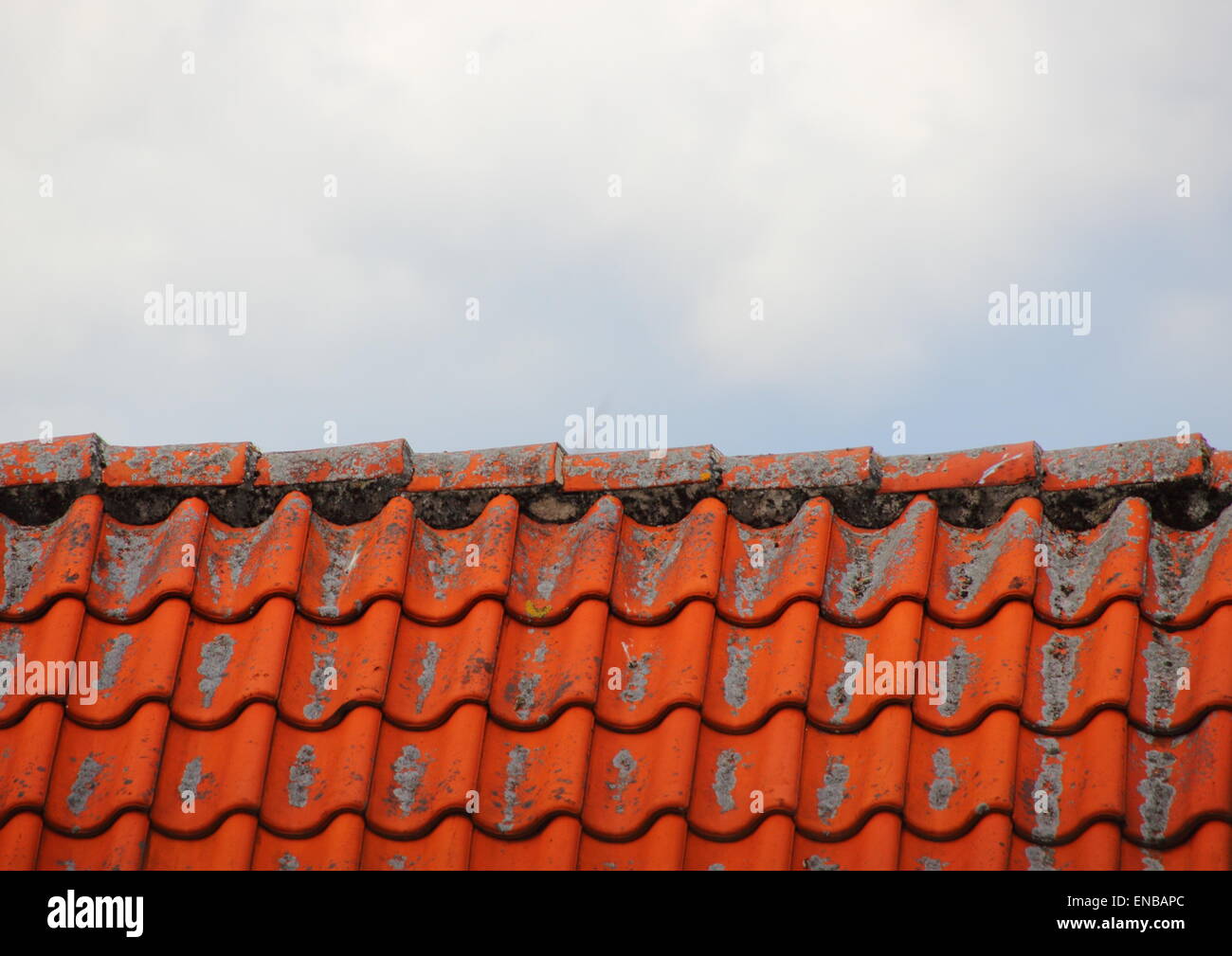 Tetto con tegole rosse e nuvole Foto Stock