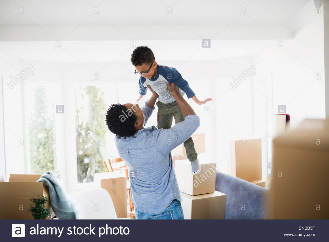 Scatole in movimento che circondano padre figlio di sollevamento Foto Stock