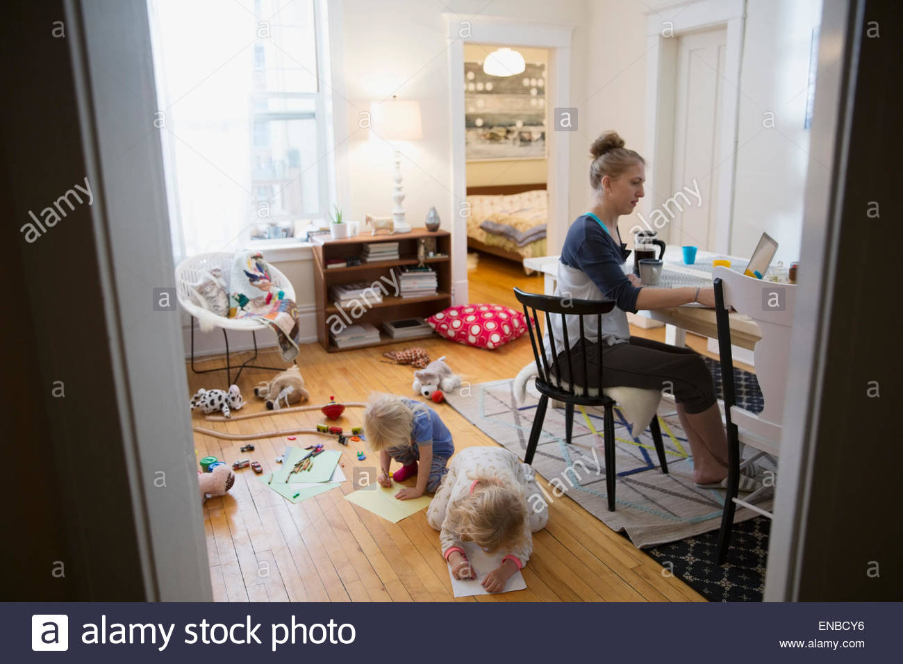 La madre lavora da casa mentre i bambini giocano Foto Stock