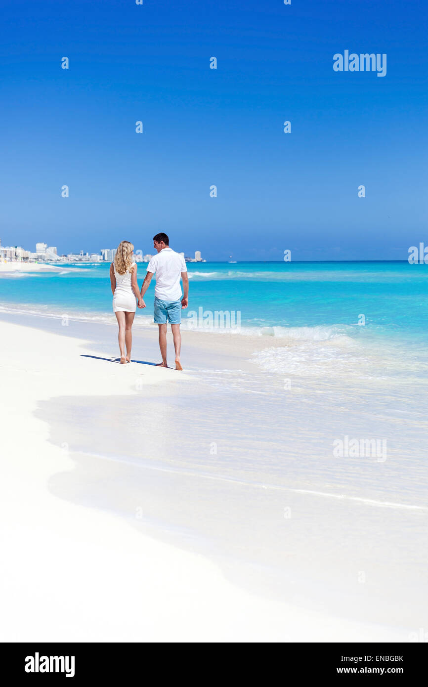 Coppia romantica camminando sulla spiaggia perfetta con il mare turchese, godersi la vita e di ogni altro in luna di miele Vacanza. Vista posteriore Foto Stock