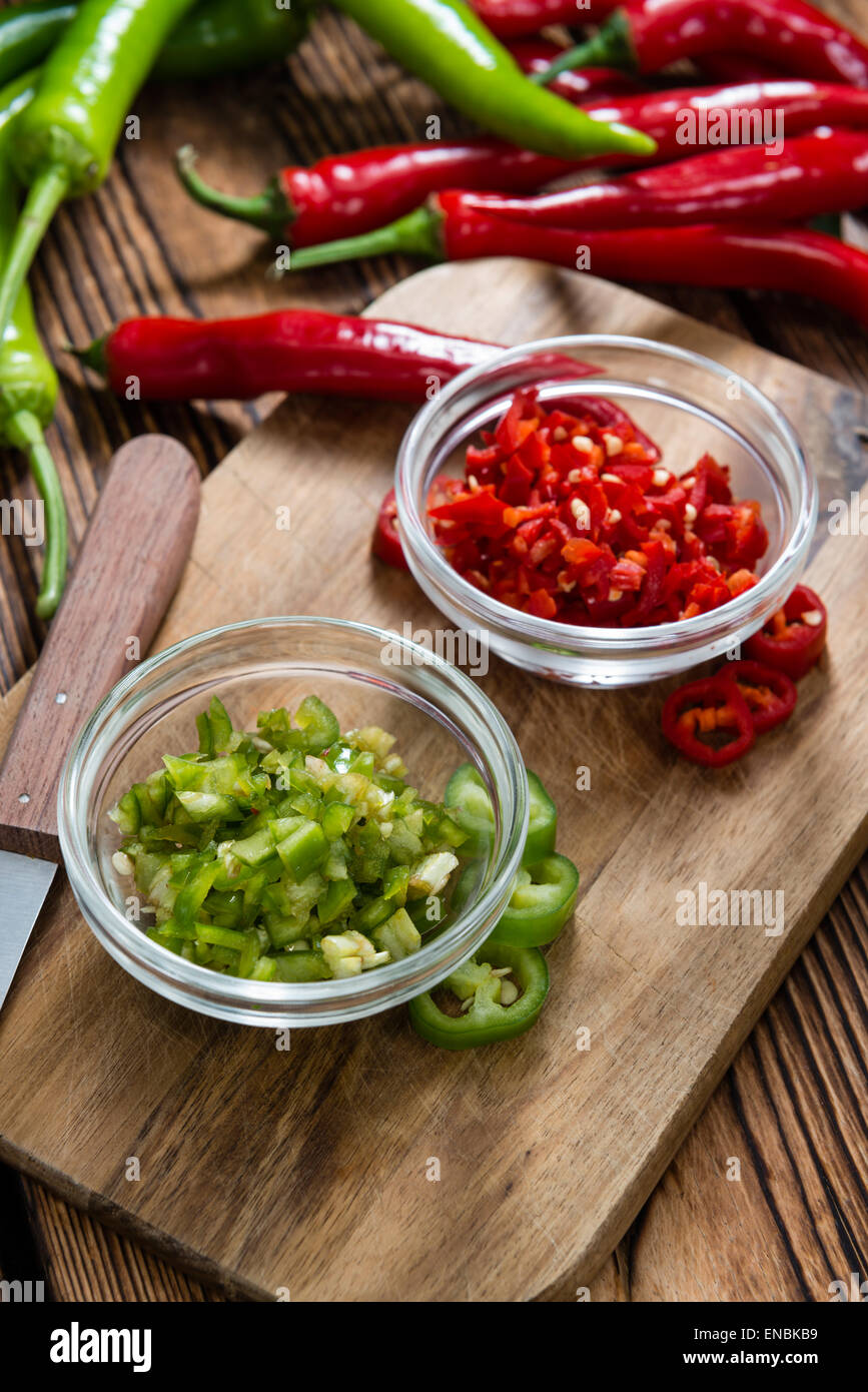 Rosso e verde (Chilis tagliato) su sfondo di legno Foto Stock