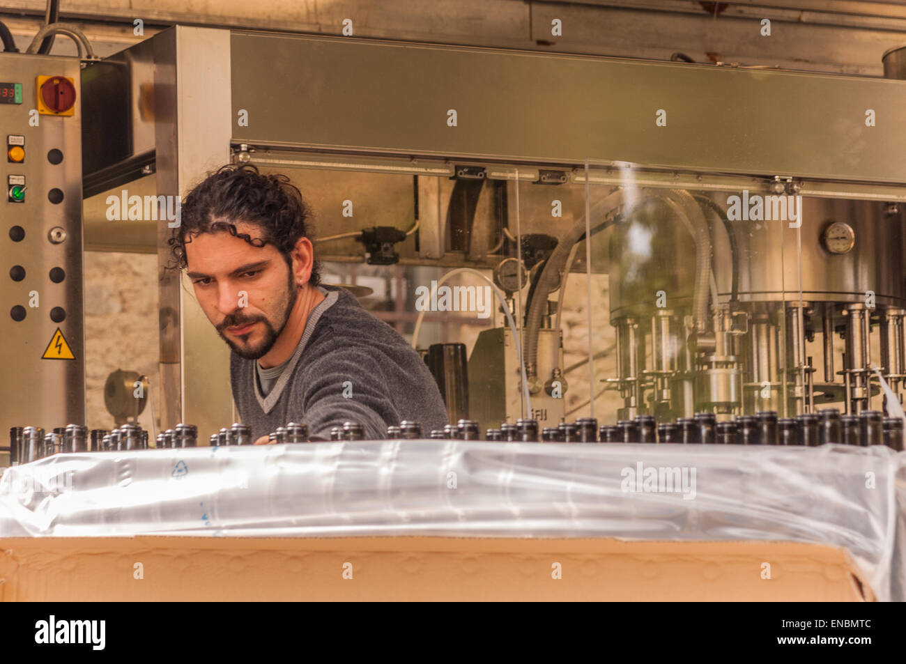 Giovane con capelli scuri e pizzetto al sito di imbottigliamento in Toscana Fattoria La striscia, Arezzo, Italia Foto Stock