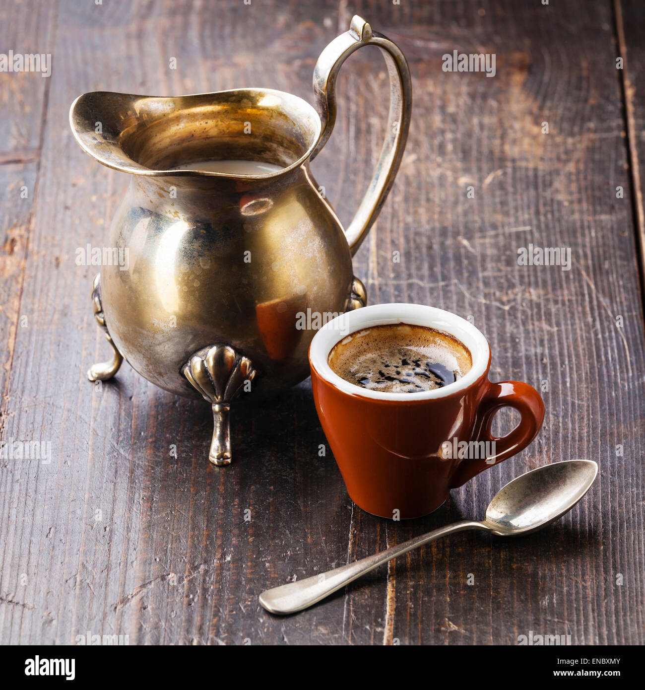 Tazza di caffè e argento creamer su sfondo di legno Foto Stock