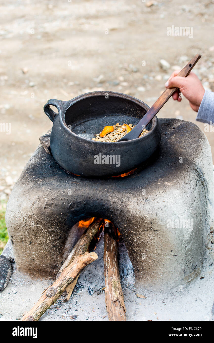 I chicchi di caffè La tostatura su un fuoco aperto con buccia di arancia a dare ulteriore gusto/sapore Foto Stock