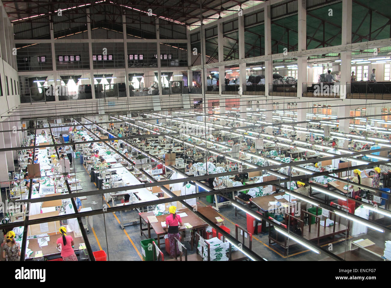 La fabbrica di abbigliamento Zabe Shweyi, fotografato il 24 marzo 2015 a Rangun, Myanmar. La società tedesca ESGE sta cercando di aiutare i responsabili locali a ottimizzare il flusso di lavoro e aumentare l'efficienza all'interno della fabbrica, come l'industria dell'abbigliamento continua a burgeon in Myanmar. Molte le fogne hanno applicato thanaka per le loro facce. Il colore bianco giallastro pasta di cosmetici è pensato per avere il raffreddamento e la bellezza di miglioramento degli effetti. Foto: Christiane Oelrich/dpa Foto Stock