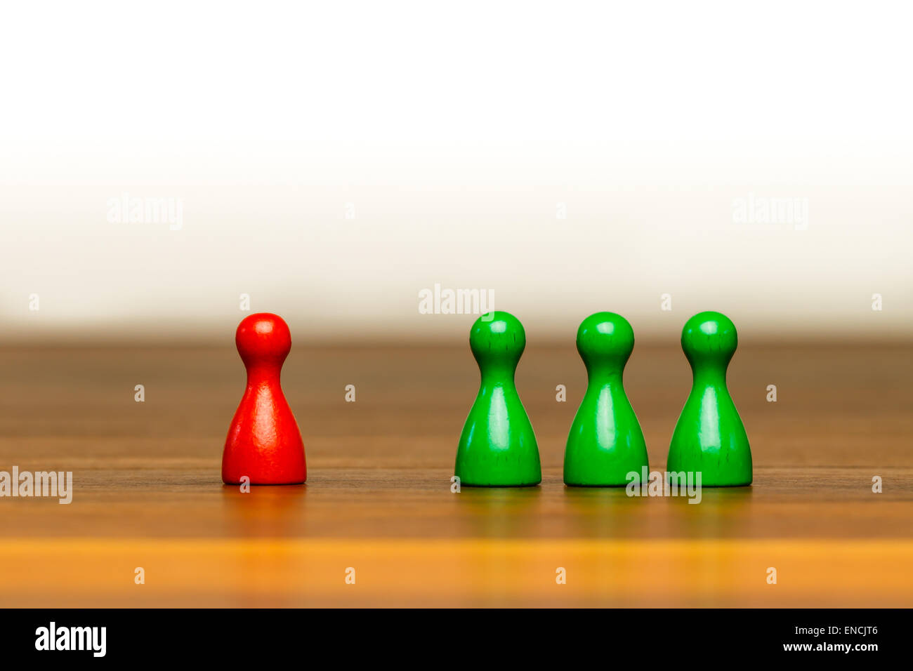 Concetto per: buona o cattiva, isolamento, di confronto, di concorrenza e di differenza. Con colorati in rosso e in verde pedina figure su legno Foto Stock