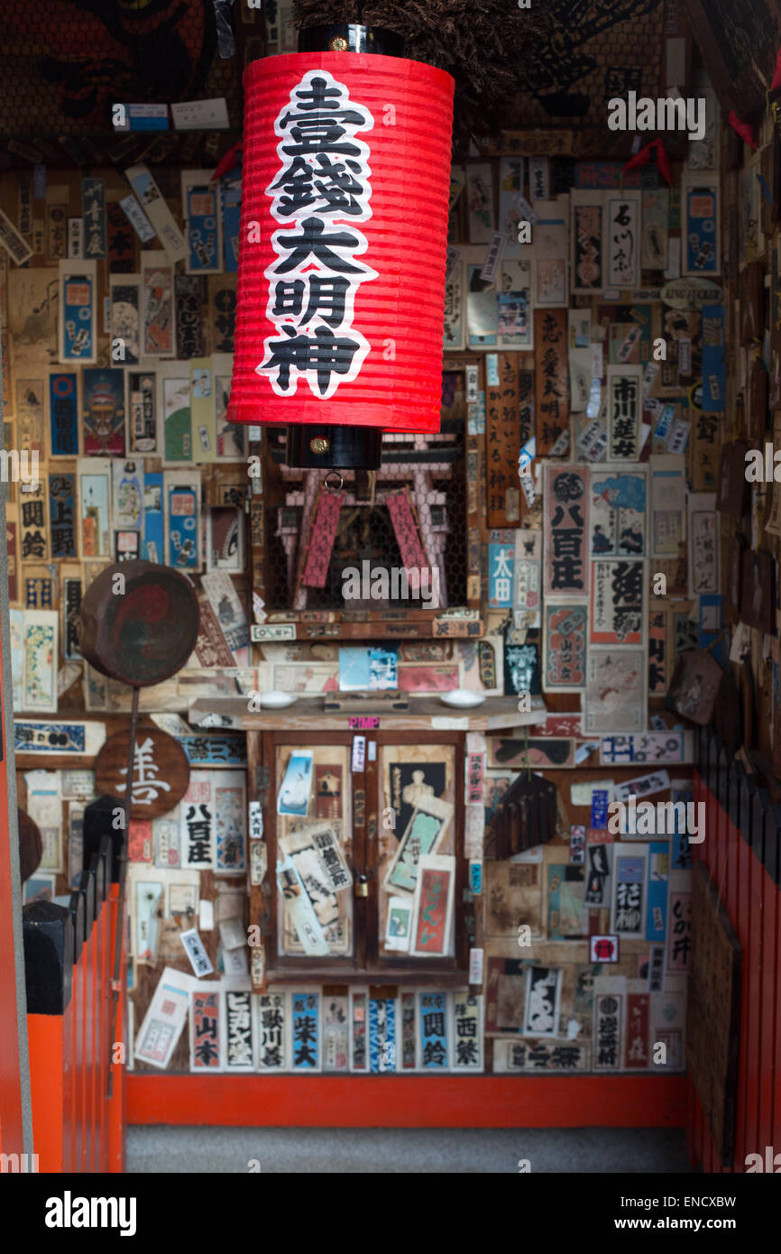 Un ristorante porta a Kyoto, in Giappone con un rosso appendere lanterne di carta e diversi volantini giapponese sulla parete. Foto Stock