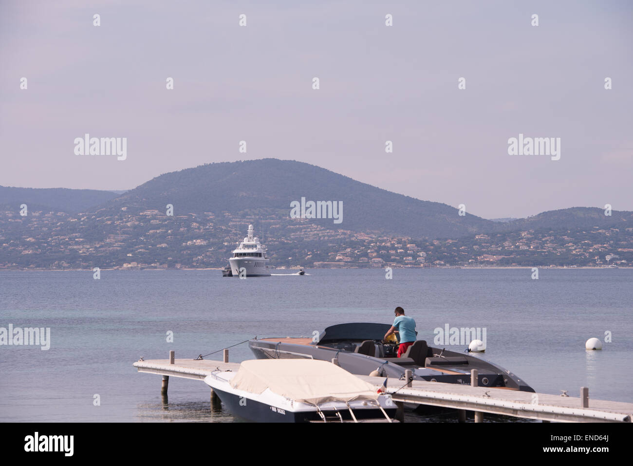 Motoscafi in St tropi, con una grande superyacht in background Foto Stock
