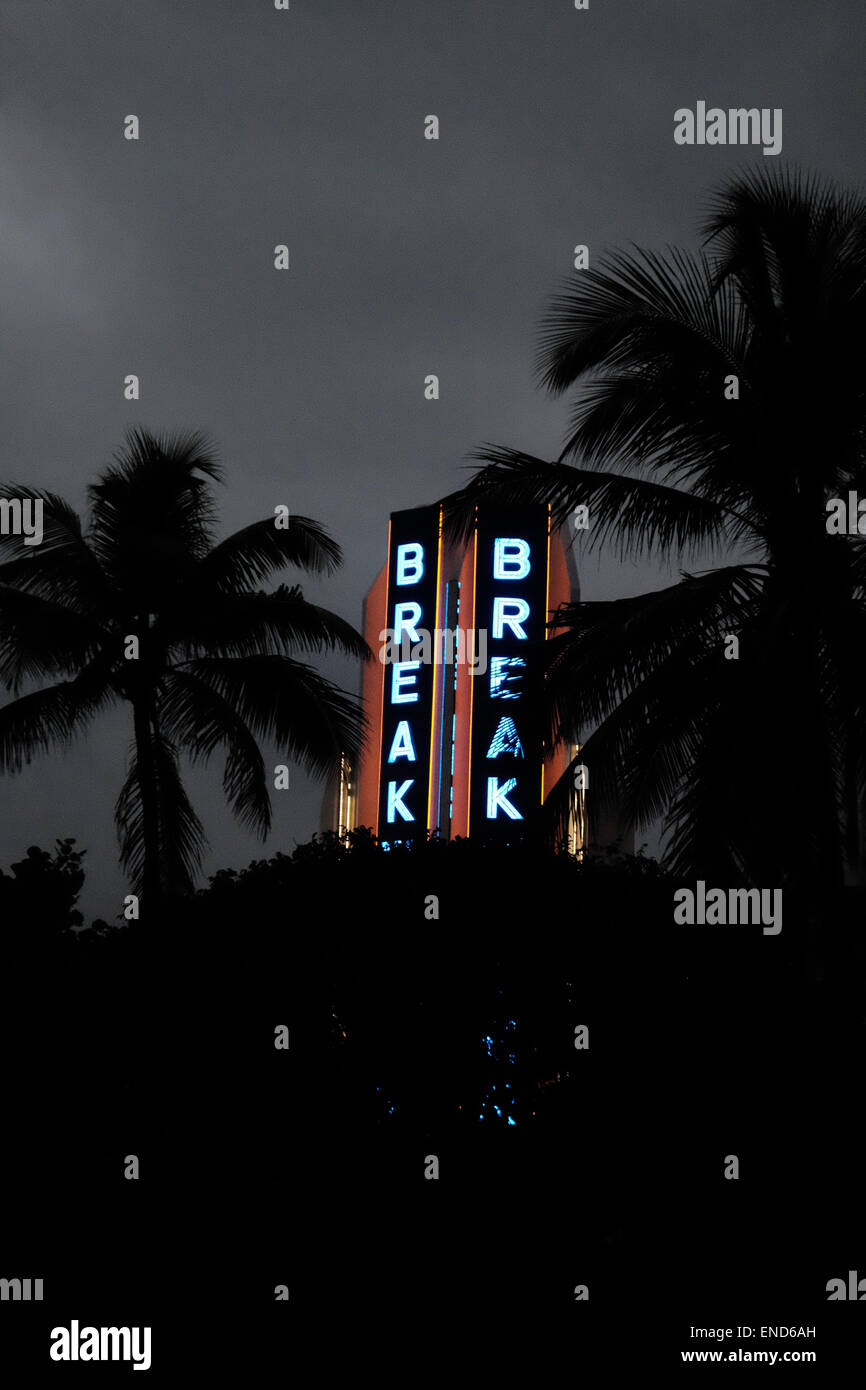 Miami Beach hotel Art Deco di notte illuminata con neon, incorniciato con palme Foto Stock