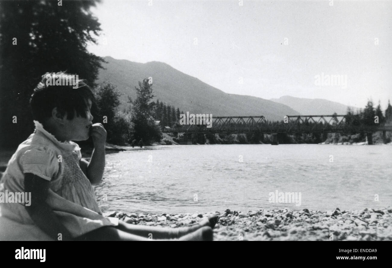 Una ragazzina siede accanto a un ponte presso il campo di Slocan, un luogo associato all'internamento giapponese canadese durante la seconda guerra mondiale Foto Stock