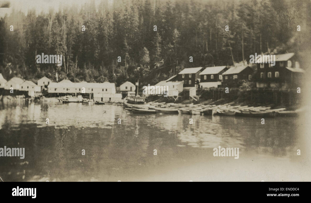 Questa fotografia cattura una tranquilla scena di sciatori ormeggiati di fronte a un molo a Beaver in agosto. Le acque tranquille e le barche sono indicative di una tranquilla atmosfera estiva, riflettendo la bellezza panoramica della posizione. Foto Stock
