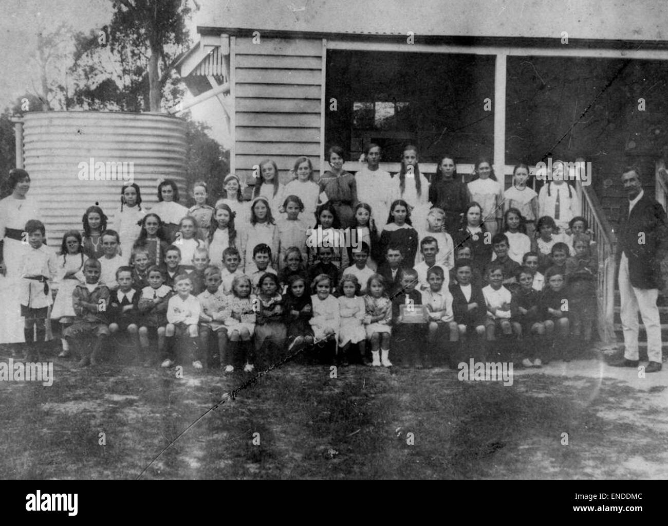 Questa fotografia di gruppo mostra studenti e insegnanti che hanno posato fuori dalla Landsborough State School, riflettendo un momento storico nell'educazione dei primi anni del XX secolo. Cattura la variegata comunità di studenti, con l'edificio scolastico come sfondo, offrendo uno sguardo alle pratiche educative del tempo. Foto Stock