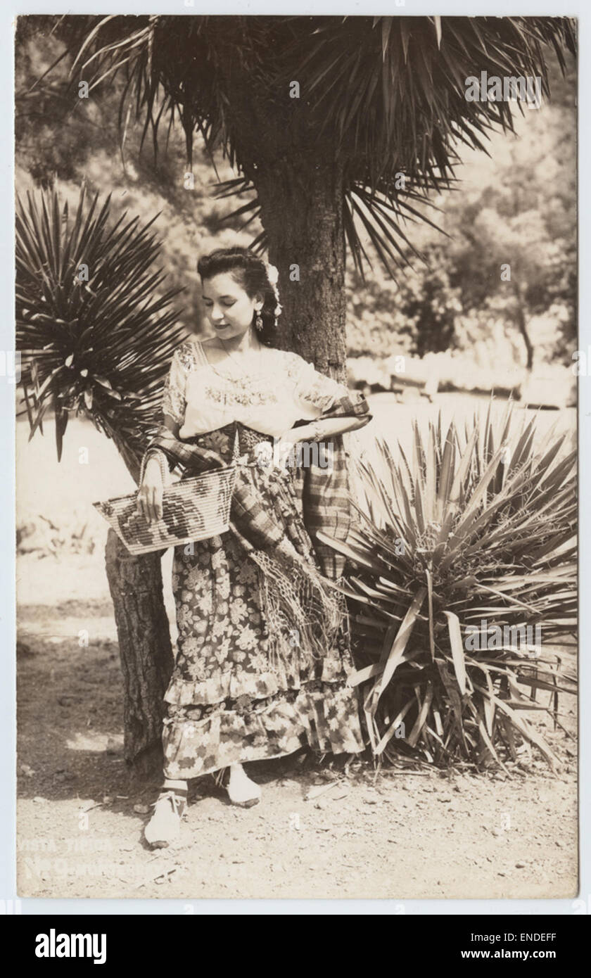 Questa vera cartolina fotografica (RPPC) cattura una scena tipica a Monterrey, Nuevo León, Messico, con donne vestite con abiti tradizionali. L'immagine offre uno sguardo sull'abbigliamento culturale della regione, mettendo in risalto la moda e lo stile di vita locale durante il tempo. Foto Stock