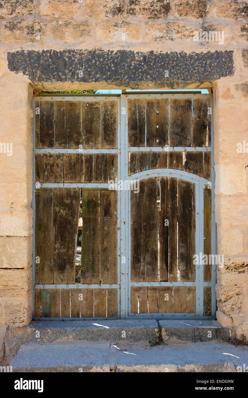 Antica porta di legno impostato nel muro di pietra Foto Stock