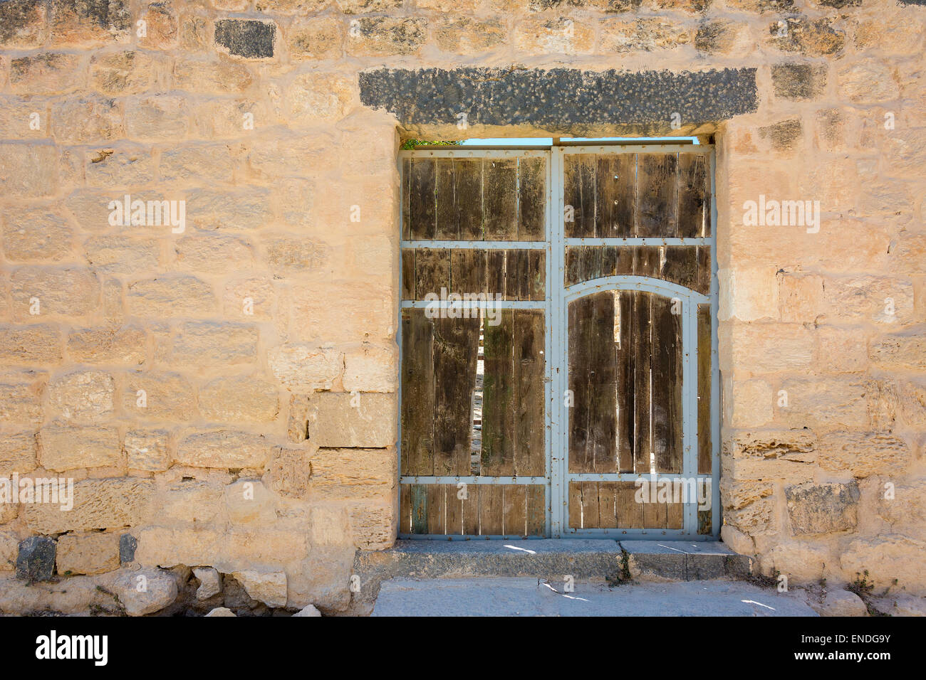 Antica porta di legno impostato nel muro di pietra Foto Stock