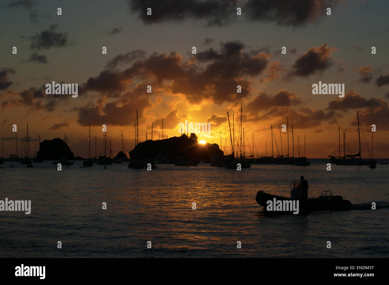 Saint-Barthélemy, French West Indies, Antille francesi, dei Caraibi: un uomo su un gommone al tramonto nella marina di Gustavia Foto Stock