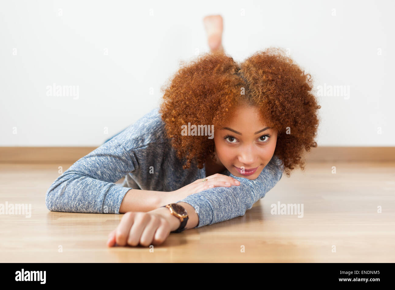 Il nero americano africano ragazza adolescente sdraiato sul pavimento in legno Foto Stock