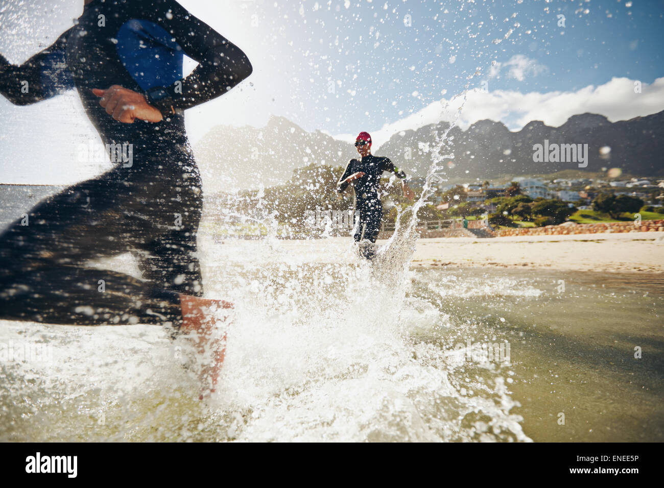 Immagine di triatleti precipitando nell'acqua. Atleta che corre in acqua e di formazione per un triathlon. Foto Stock