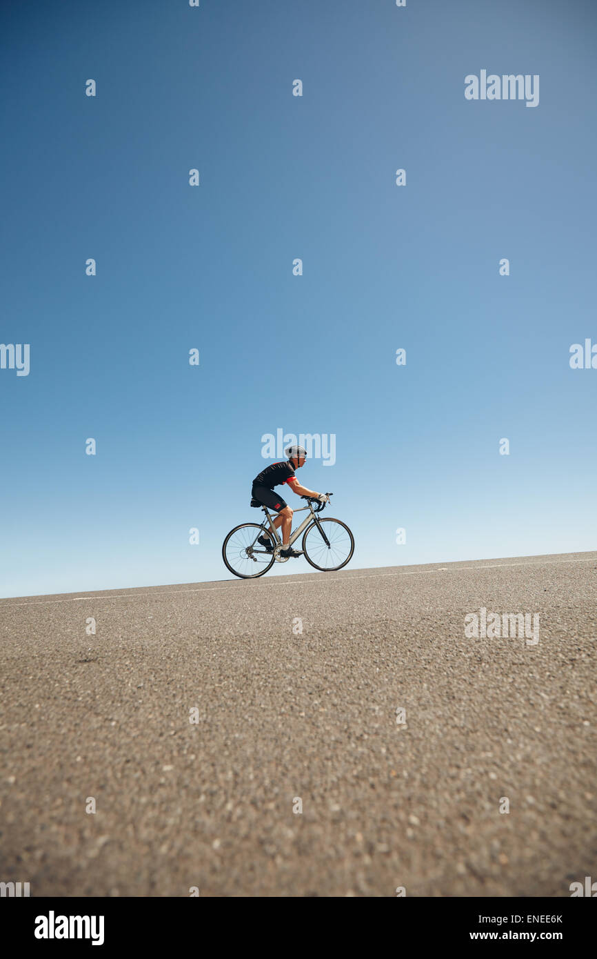 Immagine del ciclista maschio Bicicletta Equitazione su per la collina. Atleta della formazione per la bicicletta in caso di triathlon. Foto Stock