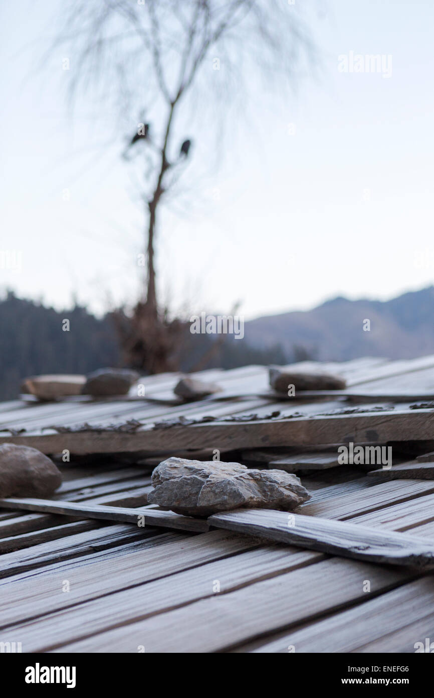 Farm shed tenuto premuto con rocce, Phobjikha Valley, Western Bhutan - Asia Foto Stock