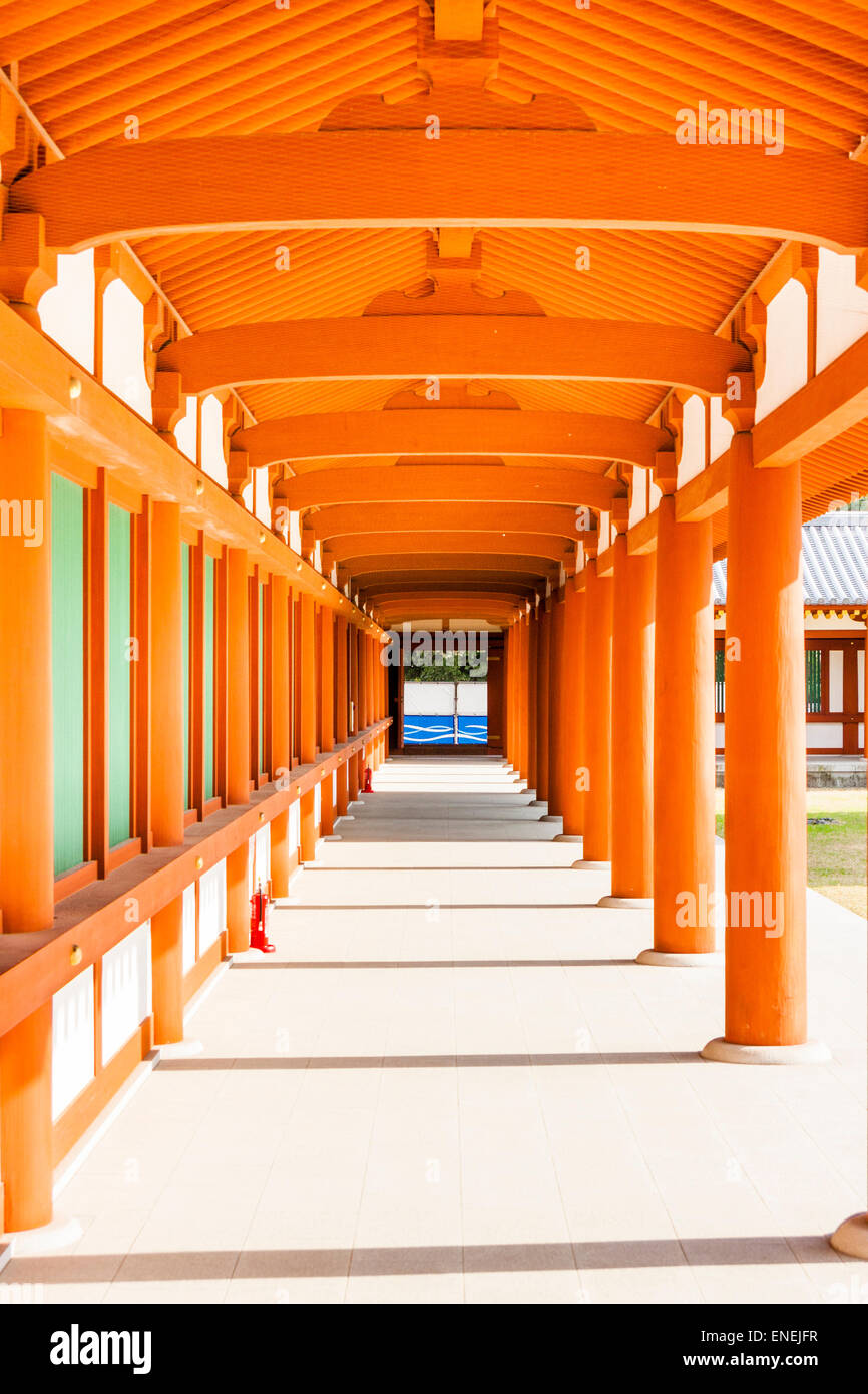 Corridoio di un santuario giapponese shintoista al tempio di Yakushiji. Vermilion e parete bianca con pannelli verdi su un lato e colonnato sull'altro. Foto Stock
